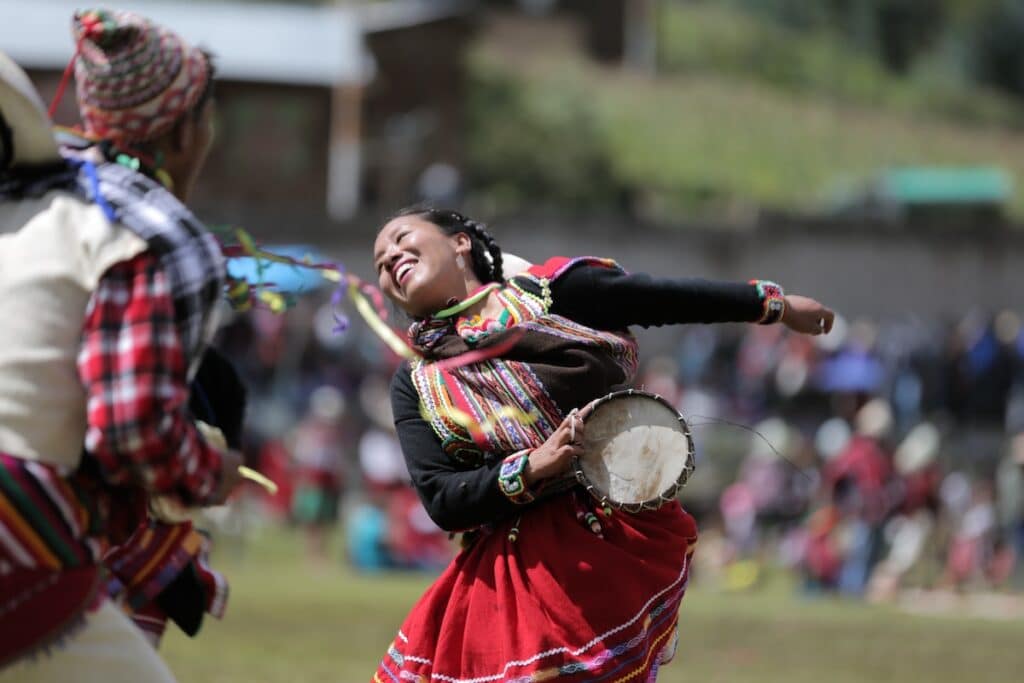Woman holding a tambourine dances in traditional clothing